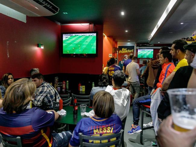 Football fans watch the match in a bar close to the Camp Nou following the decision to play the game behind closed doors. Picture: Cesar Manso/AFP