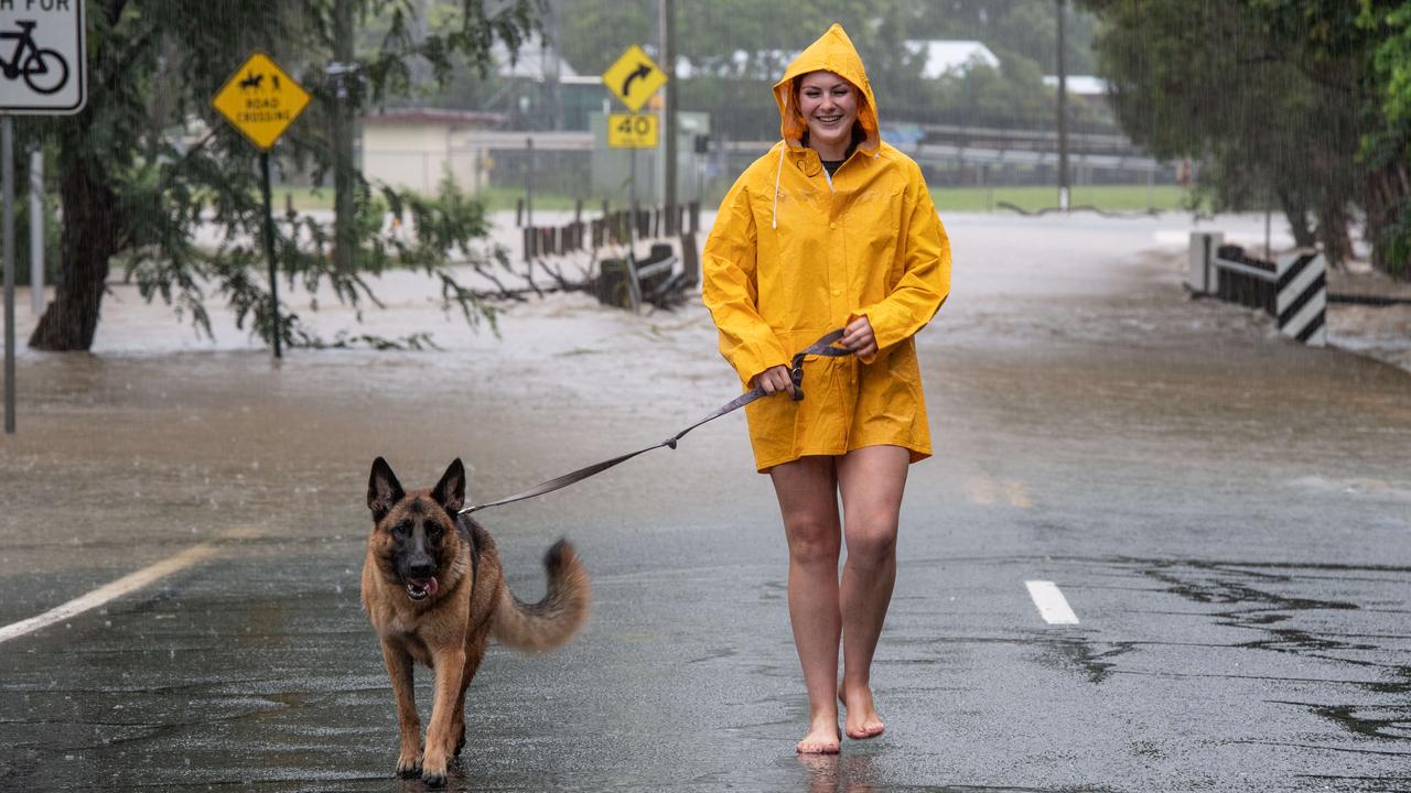 Shayde Dwyer with her dog Akira inspects floodwaters on Hill St in Pomona which has blocked access to the town. Picture: Brad Fleet