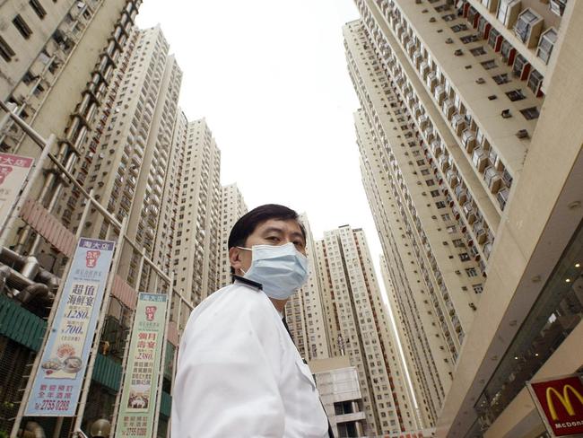 Urban jungle ...  A security guard wears a mask in Hong Kong where an apartment block was quarantined.