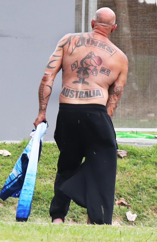 An alleged Finks bikie walks away after being charged for allegedly having bikie related items. Picture Glenn Hampson