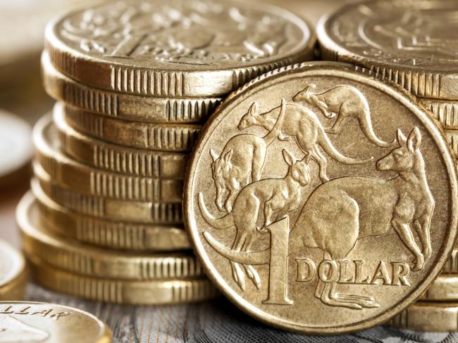 Stacks of Australian one dollar coins. Focus on front coin.