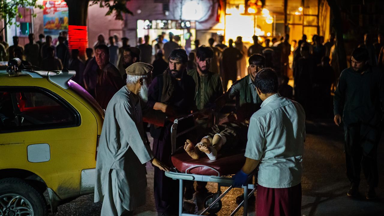 A patient is brought by a taxi to hospital after two bombings struck near the entrance of Kabul airport. Picture: Marcus Yam/Los Angeles Times