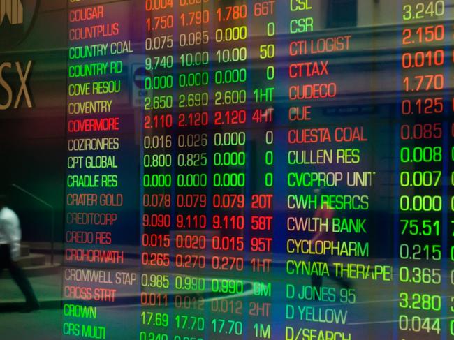 Sydney, Australia - March 5, 2014: An office worker crossing a road is reflected in the glass display of a trading screen at the Australian Stock Exchange on Bridge Street.