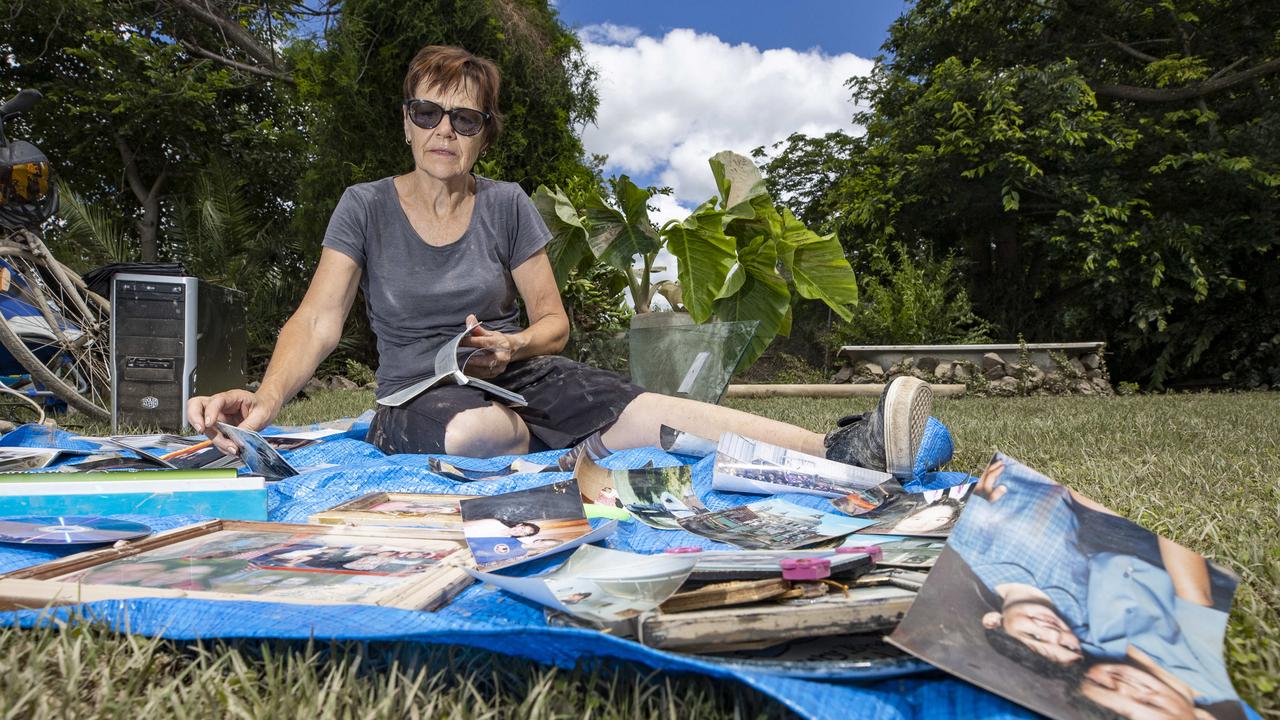 Sandy Hobbs attempts to dry out photos from family albums damaged as floodwaters inundated her property on George street in Inglewood. Picture: Lachie Millard