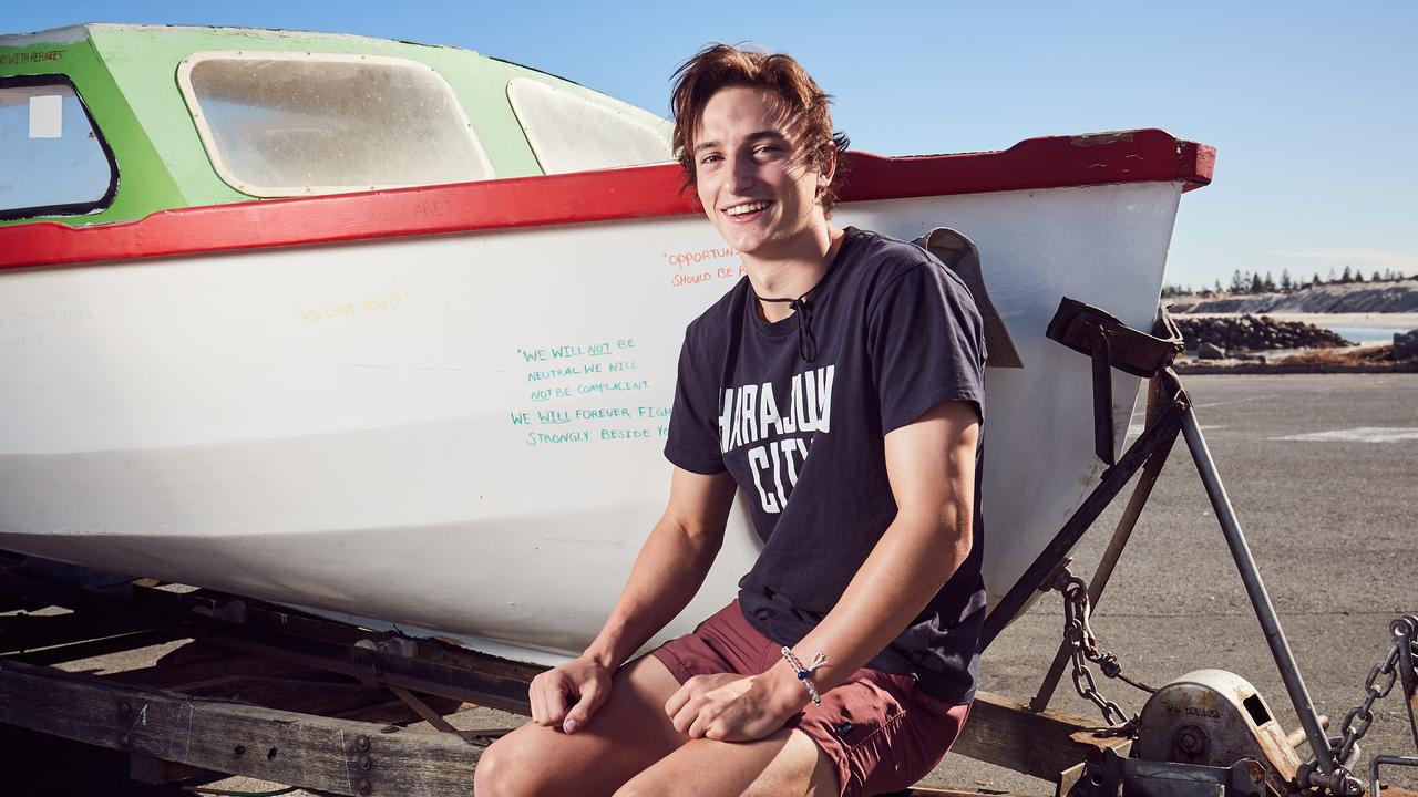 Alex Cusack poses for a picture with his second-hand boat in West Beach, before spending 48 hours off the coast of Adelaide with limited food, water and supplies to draw attention to the global refugee crisis, Thursday, April 19, 2018. (AAP Image/MATT LOXTON)