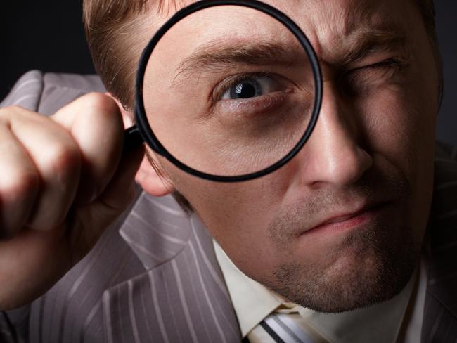 man with magnifying glass in business suit. tax generic businessman