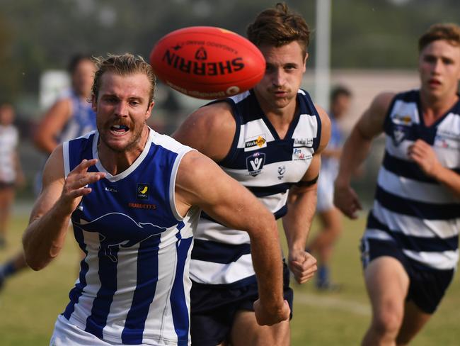 Jason Curry of Langwarren (left) chases the ball during the MPNFL Division 2 match at Pearcedale Recreation Reserve, Pearedale, Victoria, Saturday, April 21, 2018. Pearcedale v Langwarrin. (AAP Image/James Ross) NO ARCHIVING