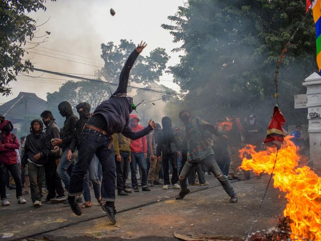 Demonstrators throw stones at the police outside the Parliament in Bandung, West Java on August 22, 2024, during a protest against a move to reverse the Constitutional Court's decision altering eligibility rules for candidates in a key election later this year. (Photo by TIMUR MATAHARI / AFP)