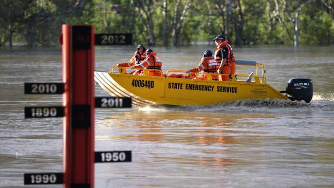 A State Emergency Service (SES) crew motors past a flood gauge on the swollen Balonne river in St George, south-western Queensland, Wednesday, February 26, 2020. The Balonne river is expected to break its banks and peak over 12 metres on Thursday, causing floods. (AAP Image/Dan Peled) NO ARCHIVING