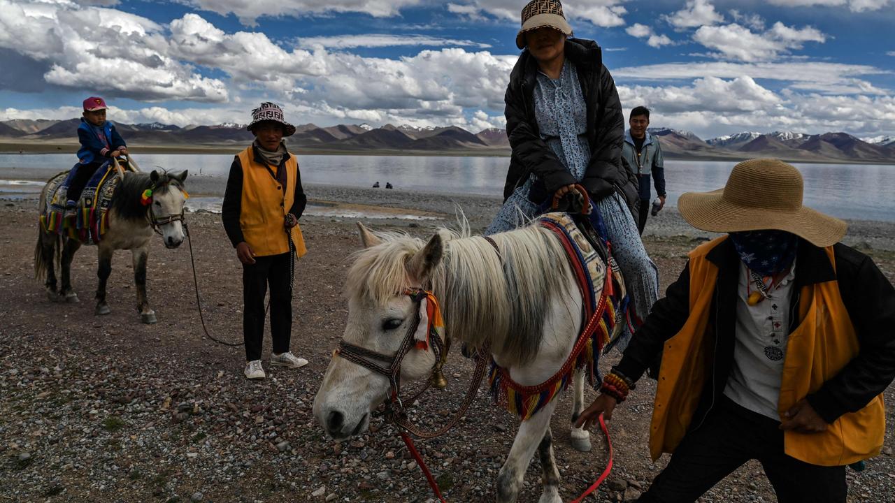 Photo shows a government organised media tour with tourists riding horses at Namtso lake in Dangxiong county, known in Tibetan as Damxung county, in China's Tibet Autonomous Region. Picture: Hector Retamal/AFP