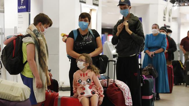 A family waits for a flight to Miami, Florida, from Silvio Pettirossi airport in Luque, on the outskirts of Asuncion, Paraguay, Thursday, April 23, 2020. Paraguay's government has organized with several other nations to get their nationals home, amid a lack of flights due to the global lockdown to contain the spread of the new coronavirus. (AP Photo/Jorge Saenz)