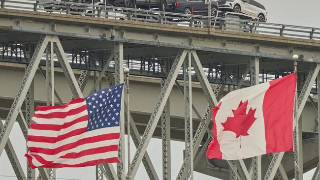 A truck loaded with vehicles crosses into the US from Ontario. Picture: Geoff Robins / AFP