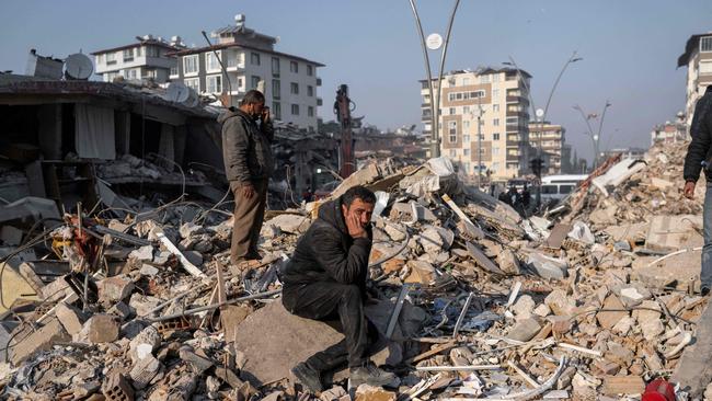 A man sits on the rubble of a collapsed building during rescue operations. Picture: AFP