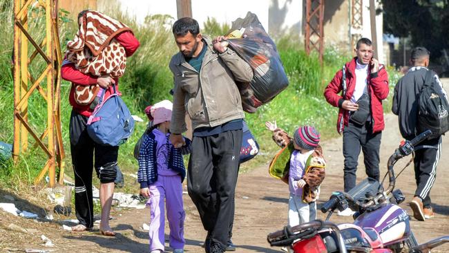 People enter northern Lebanon after crossing the Nahr al-Kabir river with Syria's western Latakia province on March 11, as families of Syria's Alawite minority flee sectarian violence along Syria's Mediterranean coast. Picture: Fathi Al-Masri/AFP