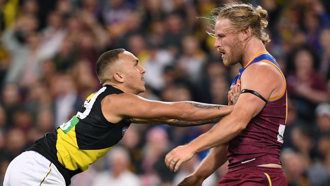 Tigers livewire Shai Bolton gives Lions veteran Daniel Rich a shove. Picture: AAP