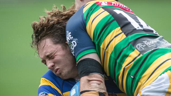 Uni player Tom Hartman is crunched by Gordon player Max Roach