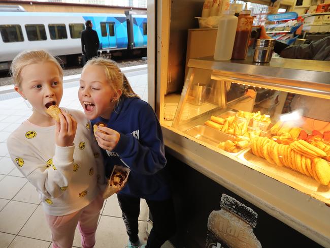 Zoe, 8, and Hope, 10, from Doreen, enjoy a snack at the only remaining Flinders St station fast-food kiosk. Picture: Alex Coppel