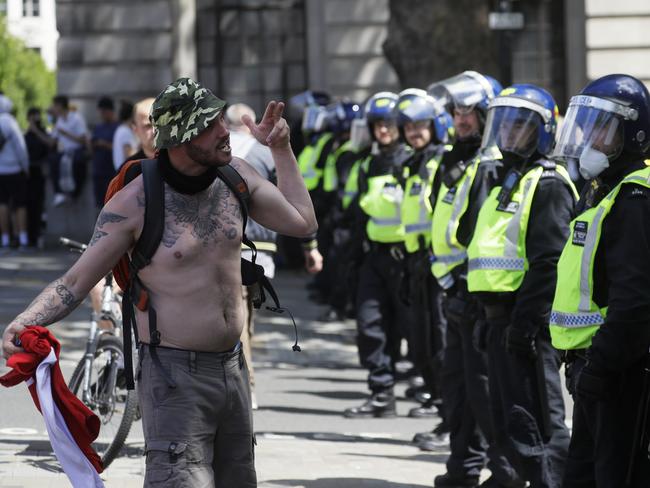 A far-right protester gestures towards British police officers in riot gear at Trafalgar Square in central London. Picture: AP