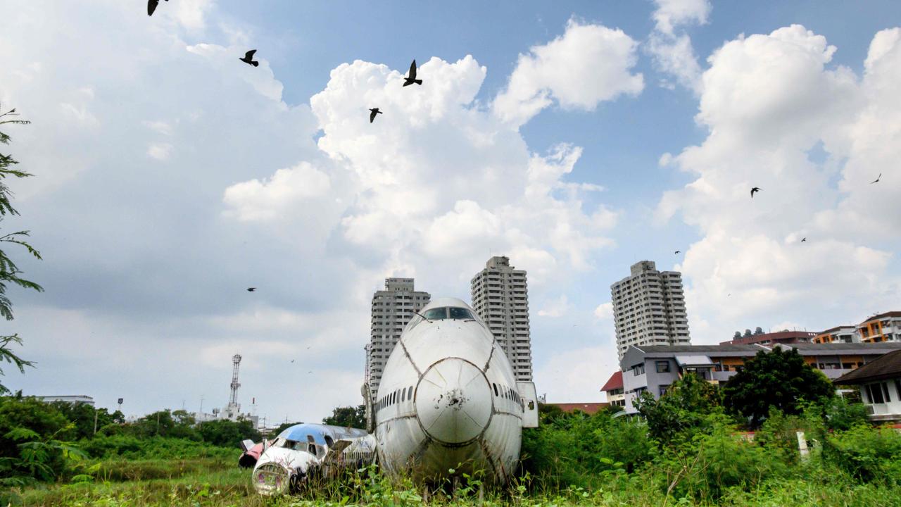 Birds fly past abandoned aircraft in the suburbs of Bangkok where three families have set up their home. Picture: Mladen Antonov / AFP