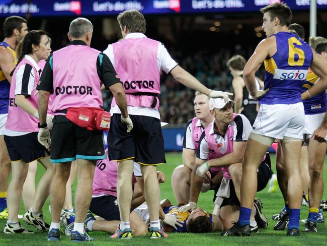 Andrew Gaff is looked at by team doctors after being knocked out by Tom Jonas.