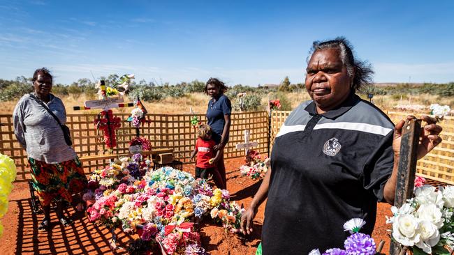 Kumanjayi Walker's foster mother Leanne Oldfield, right, visiting his grave in Yuendumu with two of Walker's other relatives, Meggery Brown and Lara. Picture: Amos Aikman