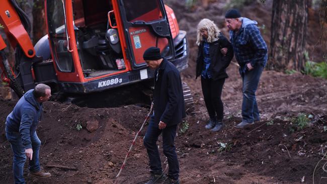 NSW Police Detective Chief Inspector Gary Jubelin (centre) brings Mark and Faye Leveson (left) down to a spot being pointed out by a fellow detective uncovered during excavation work as they continued to search bushland in the Royal National Park south of Sydney, earlier today. Picture: Dean Lewins