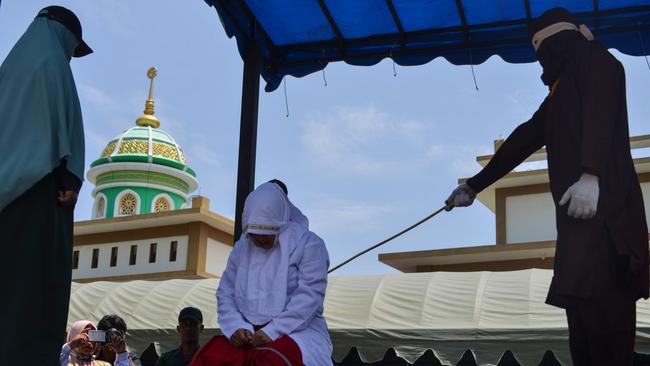 An Indonesian woman is whipped by a member of the Sharia police in public in Banda Aceh this month. Picture:AFP