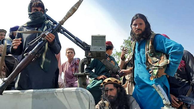 Taliban fighters sit over a vehicle on a street in Laghman province. Picture: AFP