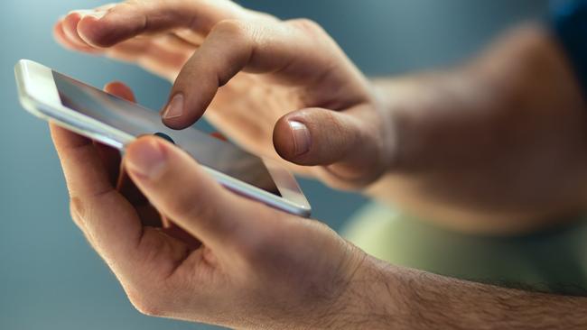 Generic Male hands typing on smartphone. Picture: Istock