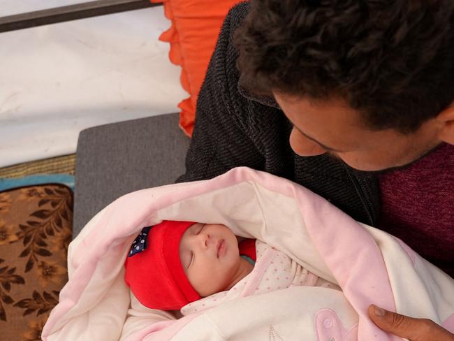 Khalil al-Suwadi holds his niece Afraa, a Syrian baby born under the rubble after the February 6 earthquake that hit Turkey and Syria and killed her parents and siblings, in the rebel-held town of Jindayris in northern Syria, on February 21, 2023. - Suwadi took the baby girl in 10 days after she was admitted to hospital in the rebel-held city of Jandaires, near the border with Turkey, where medical staff performed a DNA test to make sure they were handing her to relatives. (Photo by Rami al SAYED / AFP)