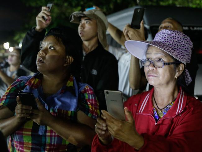 Onlookers watch and cheer as ambulances deliver boys rescued from a cave in northern Thailand to hospital in Chiang Rai after they were transported by helicopters. Picture: Lauren DeCicca/Getty Images