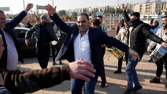 Men just released from prison dance at the entrance of Aleppo city, on December 9, 2024, as people wait for the return of relatives after the release of detainees from Syrian government prisons following the ousting of Syria's president. Picture: AFP