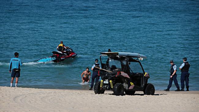 Authorities round up a lone swimmer at a closed Coogee Beach on Friday. Photographer: Adam Yip