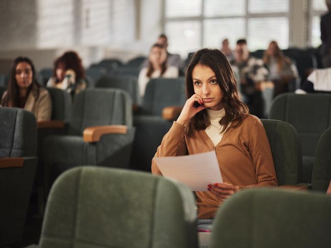 Female college student feeling displeased after receiving educational test results during a class in amphitheater. Getty Images