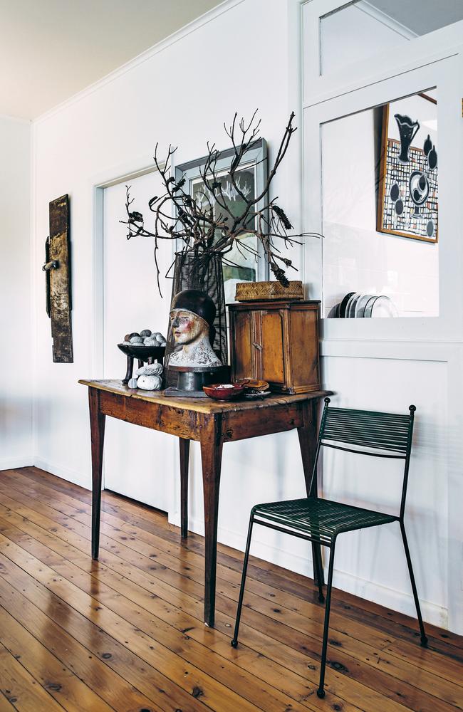 The hallway works as an art gallery. The table is made from eucalyptus and packing case pine.