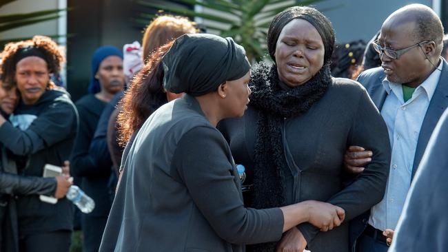 Mourners comfort each other outside the church. Picture: Jay Town