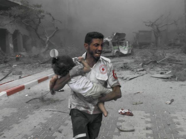 A medical worker rushes a child to an ambulance for treatment after Israeli air strikes. Picture: Belal Khaled/Anadolu Agency via Getty Images