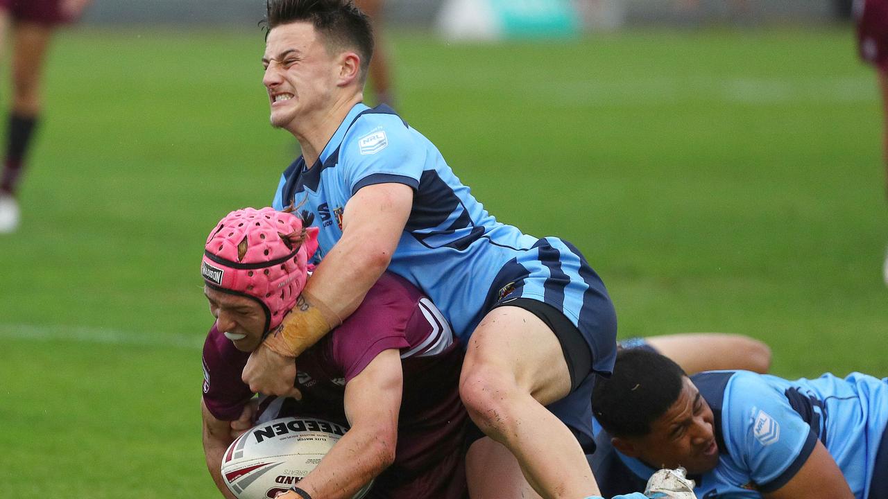 Queensland’s Braithen Scott is tackled by NSW’s Alex Isdale. Picture: Tertius Pickard