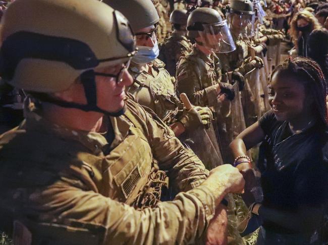 A Utah National Guard soldier fist-bumps with a demonstrator near the White House. Picture: Alex Brandon