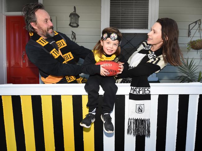 Jason Mariniello (who supports Richmond) and his wife Suzie (who barracks for Collingwood) have painted their front fence in mixed colours. Picture: Tony Gough