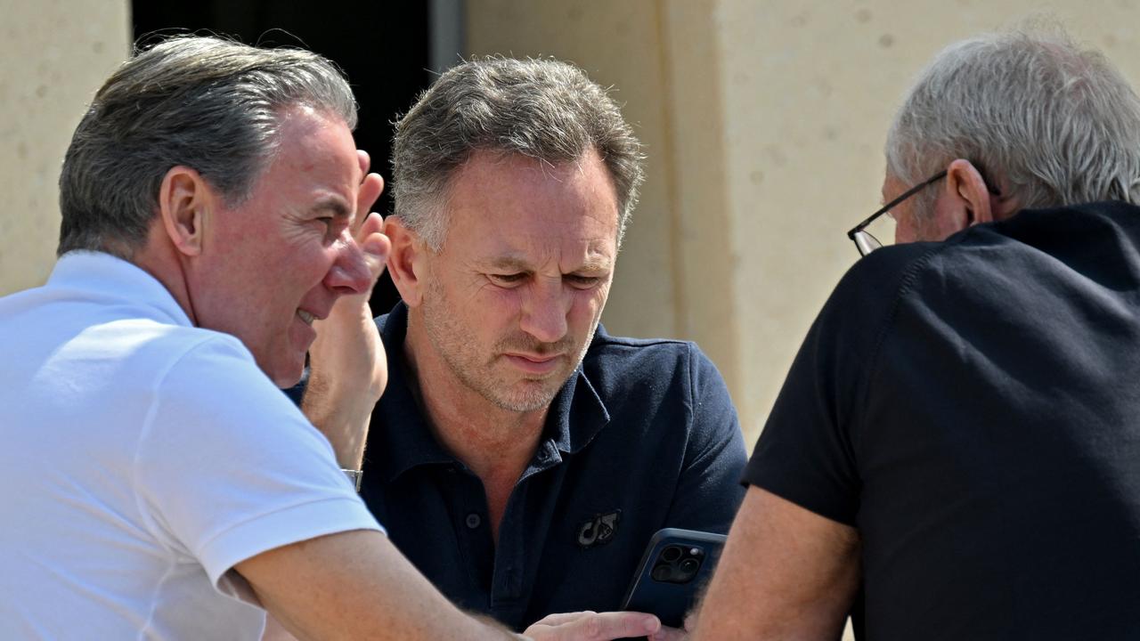 Christian Horner (centre) with team adviser Helmut Marko (left) during the third day of Formula One pre-season in Bahrain. (Photo by Andrej ISAKOVIC / AFP)