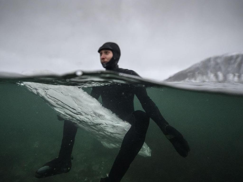 Swedish surfer Pontus Hallin waits for waves as he sits on his melting ice surfboard at the Delp surfing spot, near Straumnes, in the Lofoten Islands, over the Arctic Circle on February 18, 2019. (AFP / Olivier Morin)