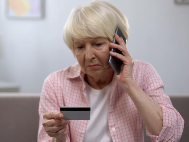 Sad old woman with credit card calling bank support, reporting about money fraud istock image