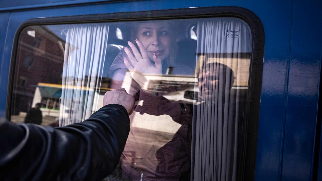 A woman waves goodbye to her husband as she leaves on a bus, a day after a rocket attack at a train station in Kramatorsk. The train station is being used for civilian evacuations, according to Donetsk region governor. Picture: Fadel Senna / AFP