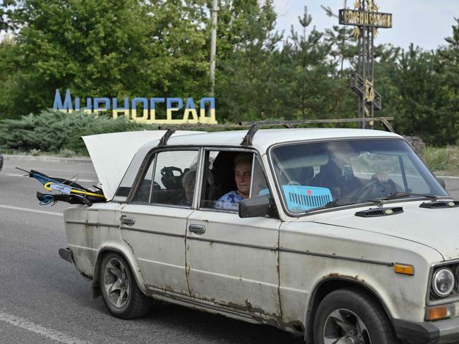 TOPSHOT - People ride in a car loaded with belongings as they leave the town of Myrnohrad on August 26, 2024, amid the Russian invasion of Ukraine. (Photo by Genya SAVILOV / AFP)