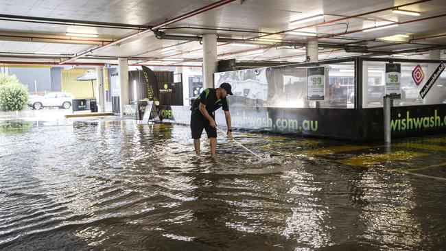 Heaving rain and flooded roads on the Gold Coast earlier this month. Staff at Home Co Bundall pictured cleaning up after the carpark flooded. Picture: Nigel Hallett