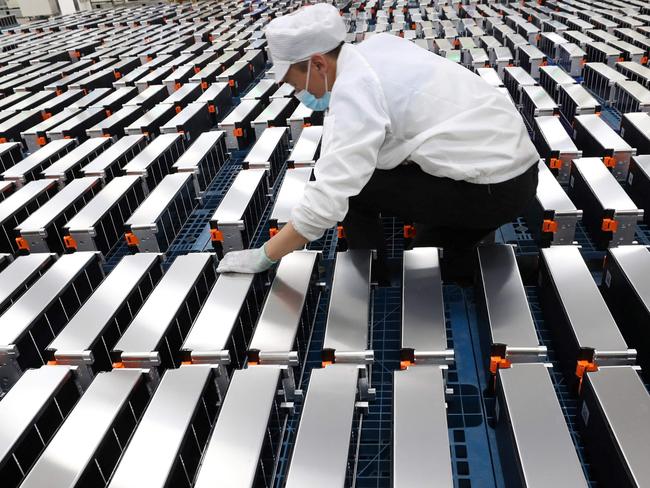 (FILES) This file photo taken on March 12, 2021 shows a worker with car batteries at a factory for Xinwangda Electric Vehicle Battery Co. Ltd, which makes lithium batteries for electric cars and other uses, in Nanjing in China's eastern Jiangsu province. - Lithium, cobalt and nickel, the metals that are essential to the manufacture of the electric batteries that will replace the combustion engines that contribute to global warming, are so sought after that Europe is preparing to open mines and refineries to try to reduce its dependence on imports. (Photo by AFP) / China OUT