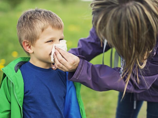 f14hayfever. Mother cleaning nose of allergic son.