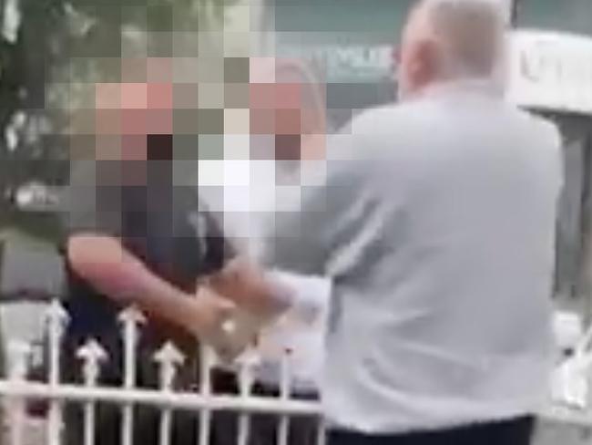 Screengrabs from  video footage obtained exclusively by The Daily Telegraph, a young woman records the moment a trio of men follow her down the street before a man in a black tshirt punches her father in the face on their driveway of Wangee Rd in the midst of a loud argument. Following more shouting, another man in a white hoodie is seen shouting and revealing a silver pistol hidden in the pocket of his jacket, before the trio take off down Wangee Rd pursued by the man they attacked.