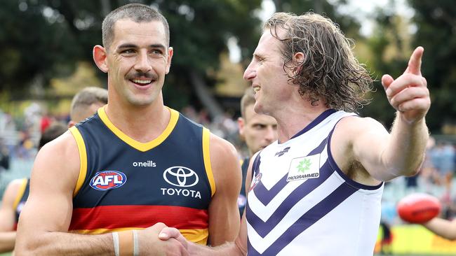 Taylor Walker was in good spirits post-game, chatting with Fremantle veteran David Mundy. Picture: Sarah Reed/AFL Photos via Getty Images